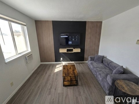 A living room with a grey couch and a wooden coffee table.