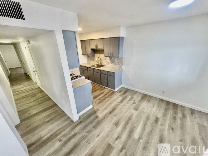 A kitchen with a sink, stove, and cabinets is available for rent.