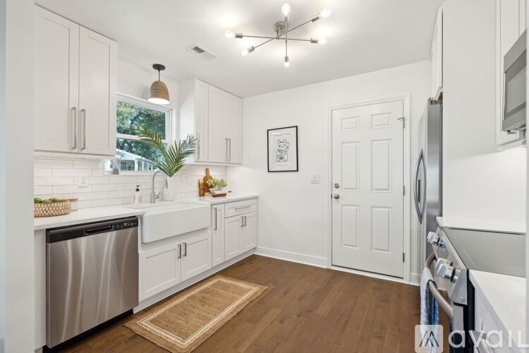 A kitchen with white cabinets and a stainless steel dishwasher.