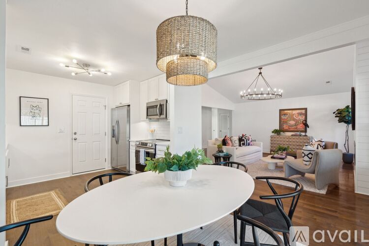 A modern dining room with a white table and chairs.