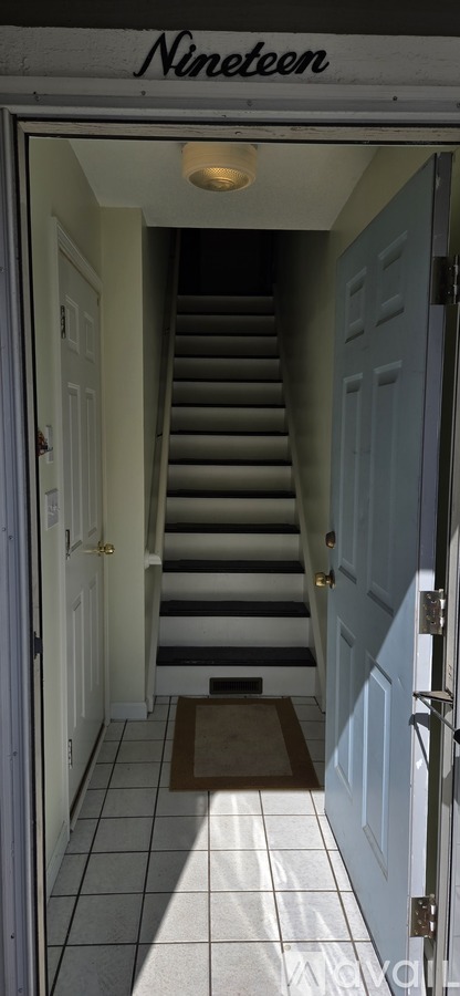 A stairway leading to a door with the word Nineteen above it.