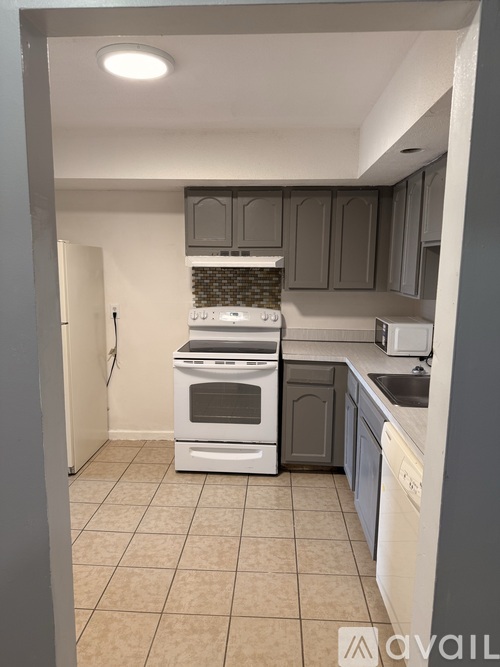 A kitchen with a white oven and sink.