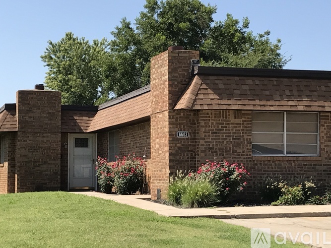 A brick house with a grey door and windows.