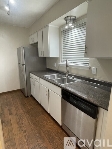 A kitchen with a stainless steel refrigerator, dishwasher, and sink.