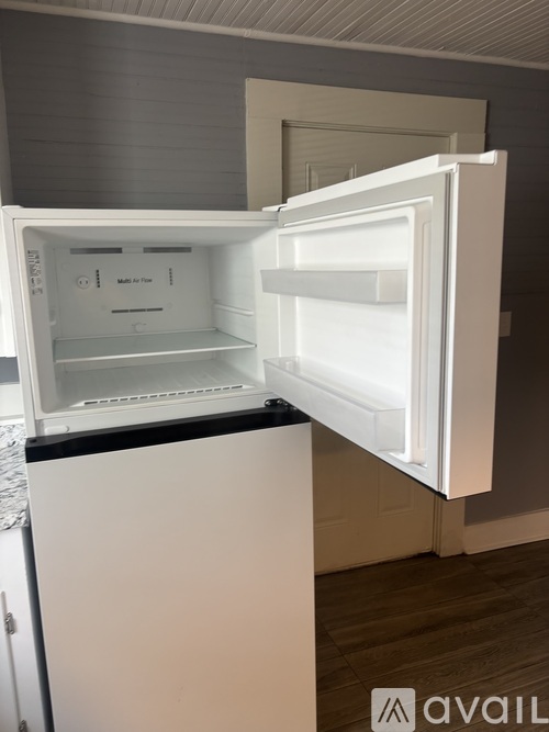 A white refrigerator with its door open in a kitchen.