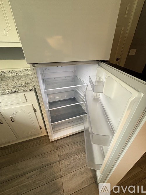 A white refrigerator with its door open and shelves visible.