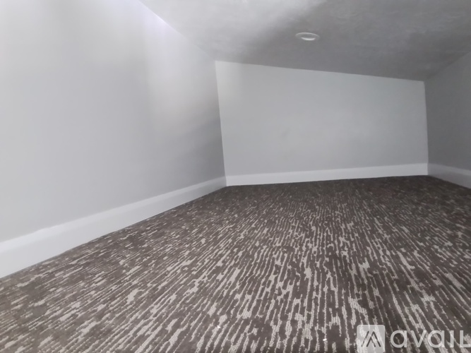 A room with a carpeted floor and white walls.