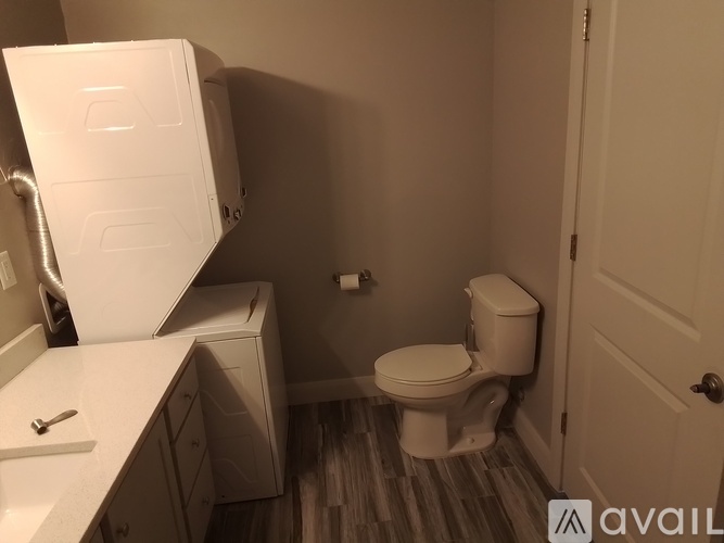 A small bathroom with a toilet, sink, and cabinet.