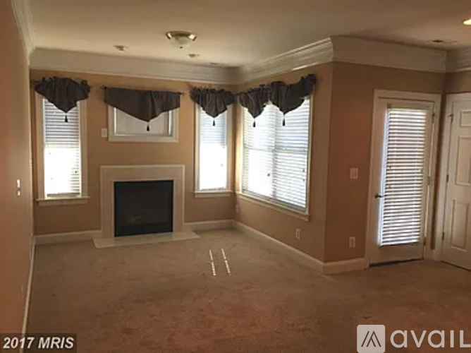 A living room with a fireplace and a window with a curtain.