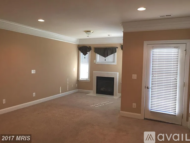 A living room with a fireplace and a window with blinds.