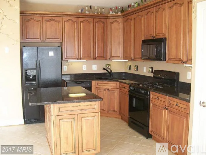 A kitchen with wooden cabinets and black appliances.