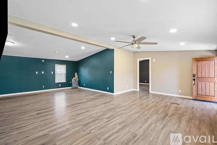 A room with wooden flooring and a ceiling fan.