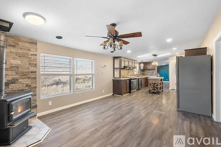 A modern kitchen with a wood stove and a fan.
