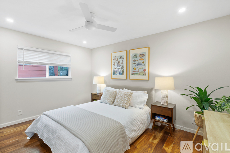 A bedroom with a large bed and two lamps.
