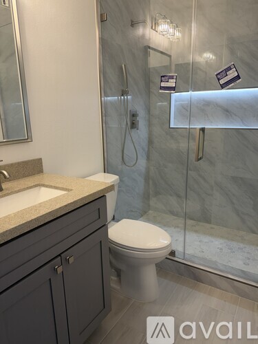 A bathroom with a toilet, sink, and shower.
