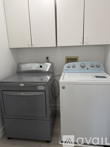 A washing machine and dryer are in a laundry room.