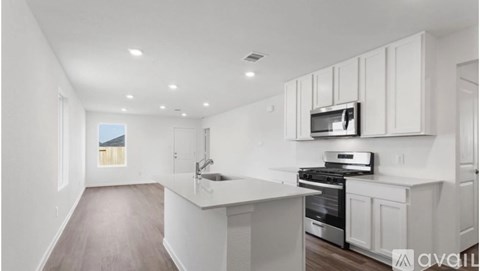 A modern kitchen with white cabinets and appliances.