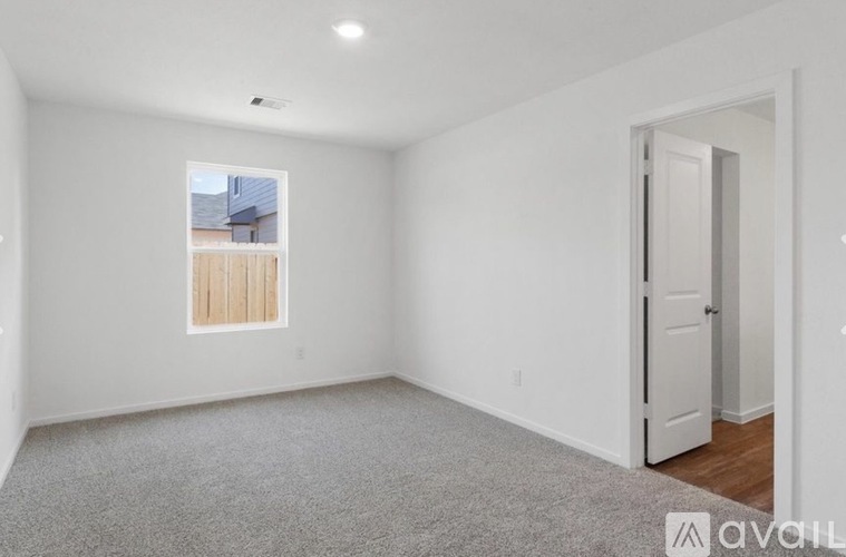 A room with a window and a door is available for rent.