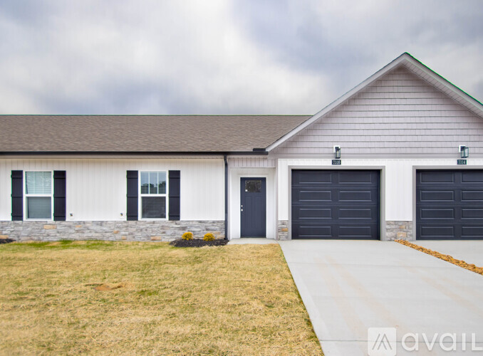 A house with a grey roof and a stone wall.
