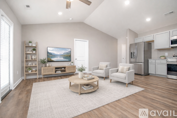 A living room with a television, a sofa, a chair, and a coffee table.