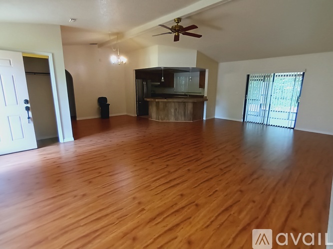 A living room with a wooden floor and a ceiling fan.