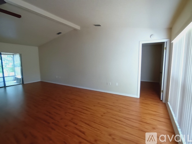 A room with wooden flooring and white walls.