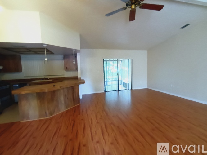 A room with wooden flooring and a ceiling fan.