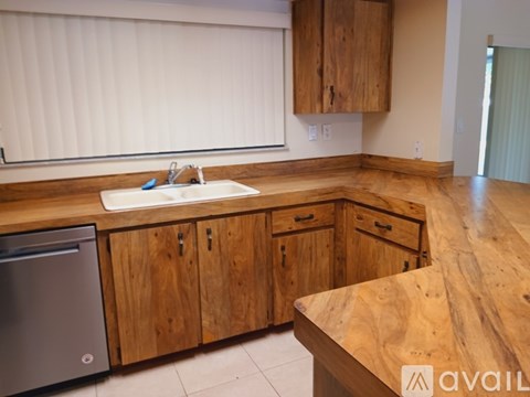 A kitchen with wooden cabinets and a wooden counter top.