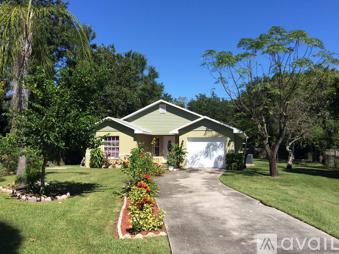 A house with a driveway and trees in the background.