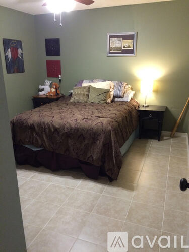 A bedroom with a bed, nightstand, and a ceiling fan.