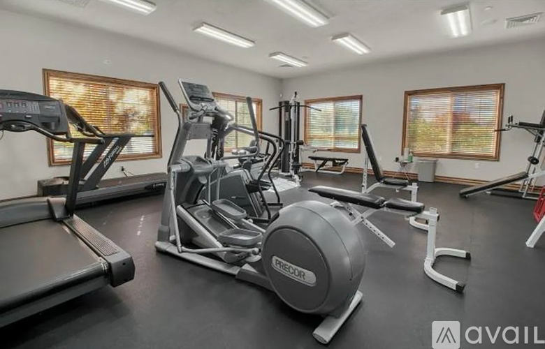 A gym with treadmills, elliptical machines, and a stationary bike.