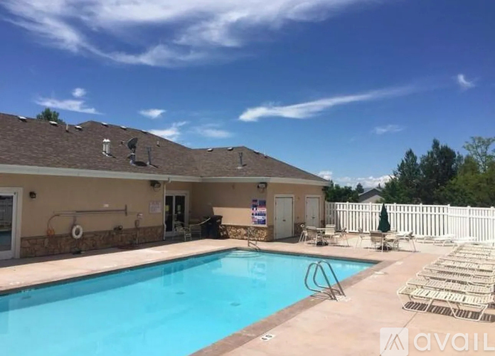A pool with a white fence and a building in the background.