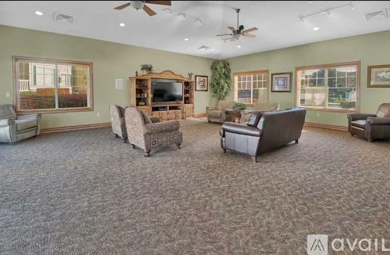 A living room with a carpeted floor and a television.