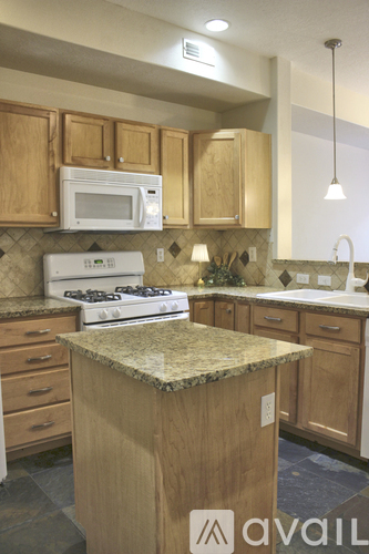 A kitchen with wooden cabinets and a granite countertop.