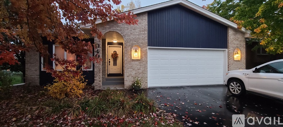 A house with a white garage door and a car parked in front.