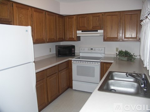A kitchen with wooden cabinets and white appliances.