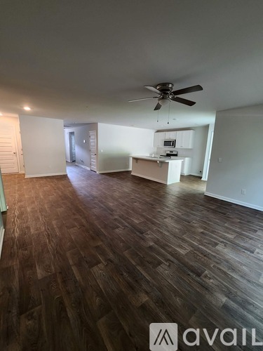 A room with wooden flooring and a ceiling fan.