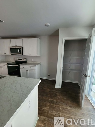 A kitchen with white cabinets and a granite countertop.