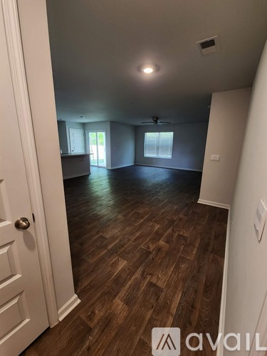 A room with wooden flooring and a white door.
