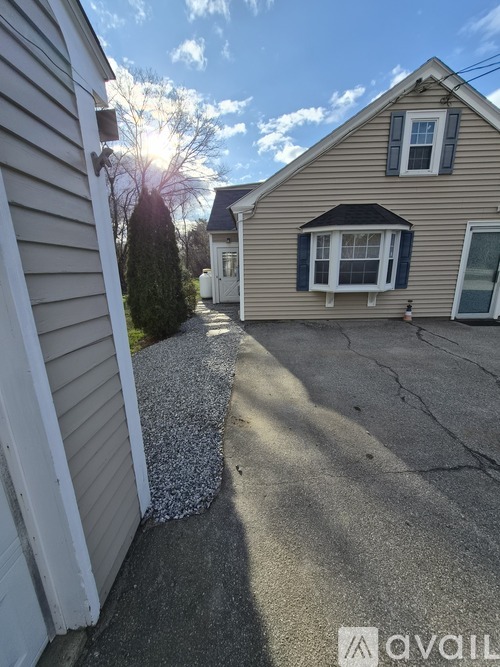 A house with a driveway and a gravel area in front.