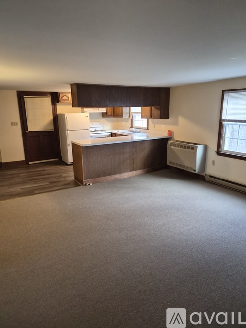 A kitchen with a refrigerator, sink, and a window.