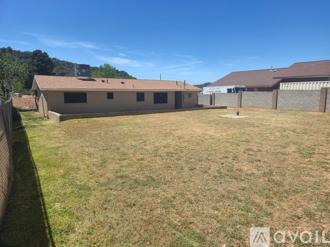 A large, open yard with a building in the background.