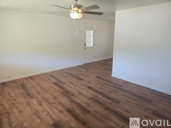 A room with wooden flooring and a ceiling fan.