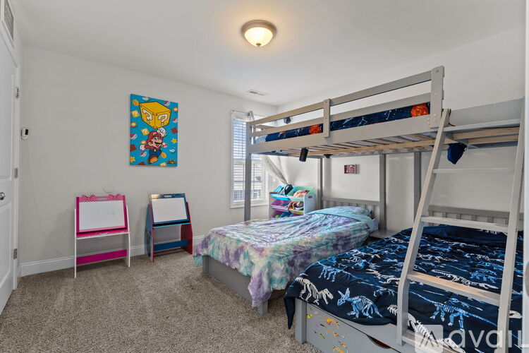 A bedroom with two bunk beds and a colorful painting on the wall.