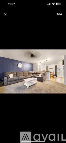 A living room with a grey sofa and a white coffee table.