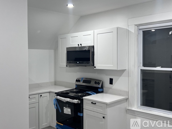 A kitchen with white cabinets and a black stove top oven.