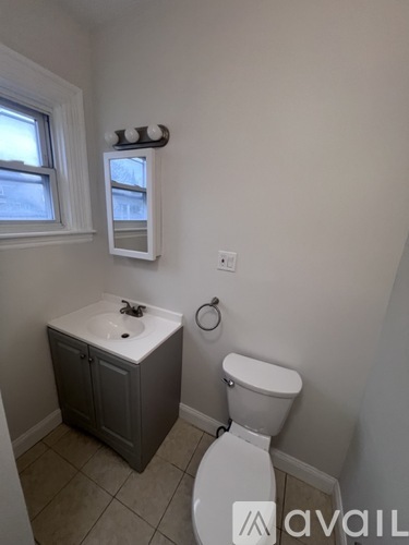 A small bathroom with a toilet, sink and window.