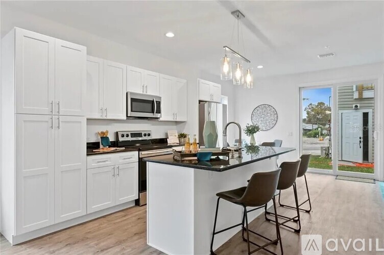 A modern kitchen with white cabinets and a black countertop.