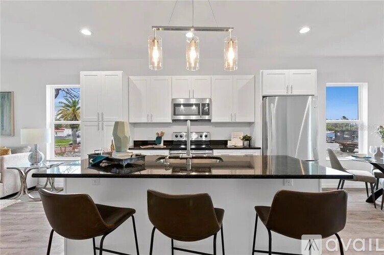 A modern kitchen with a large island and chairs.