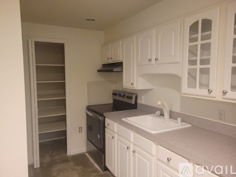 A kitchen with white cabinets and a black dishwasher.